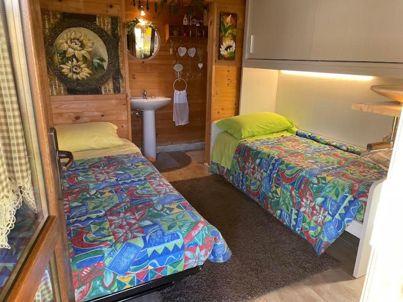 Habitación con 2 camas y lavamanos en una cabaña en Casa Nuvola, en SantʼAndrea