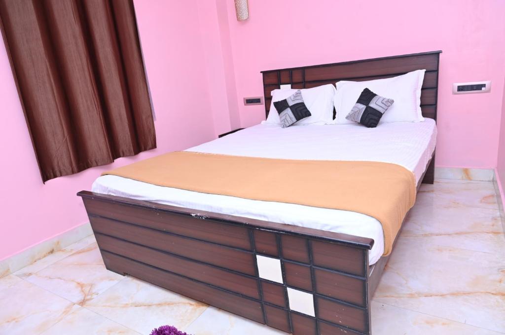 a bedroom with a large bed in a pink room at HOTEL BEACH A/C in Port Blair