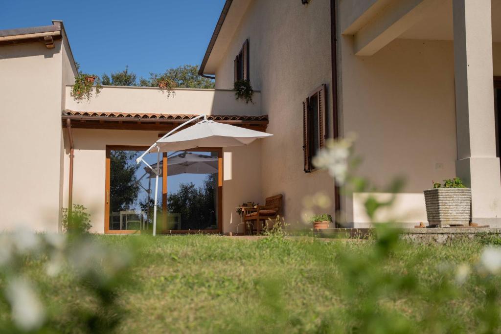 a house with an umbrella in front of a yard at Poggio delle Ginestre in Orvieto