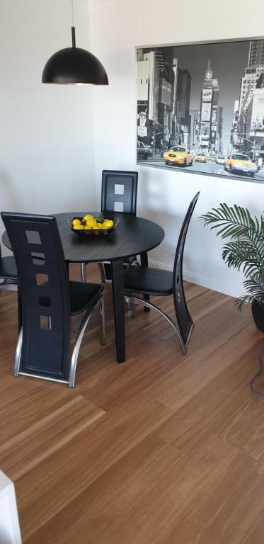 布里斯本的住宿－Best Value With City View Sleeps 7，一张黑色餐桌,配有两把椅子和一盘香蕉