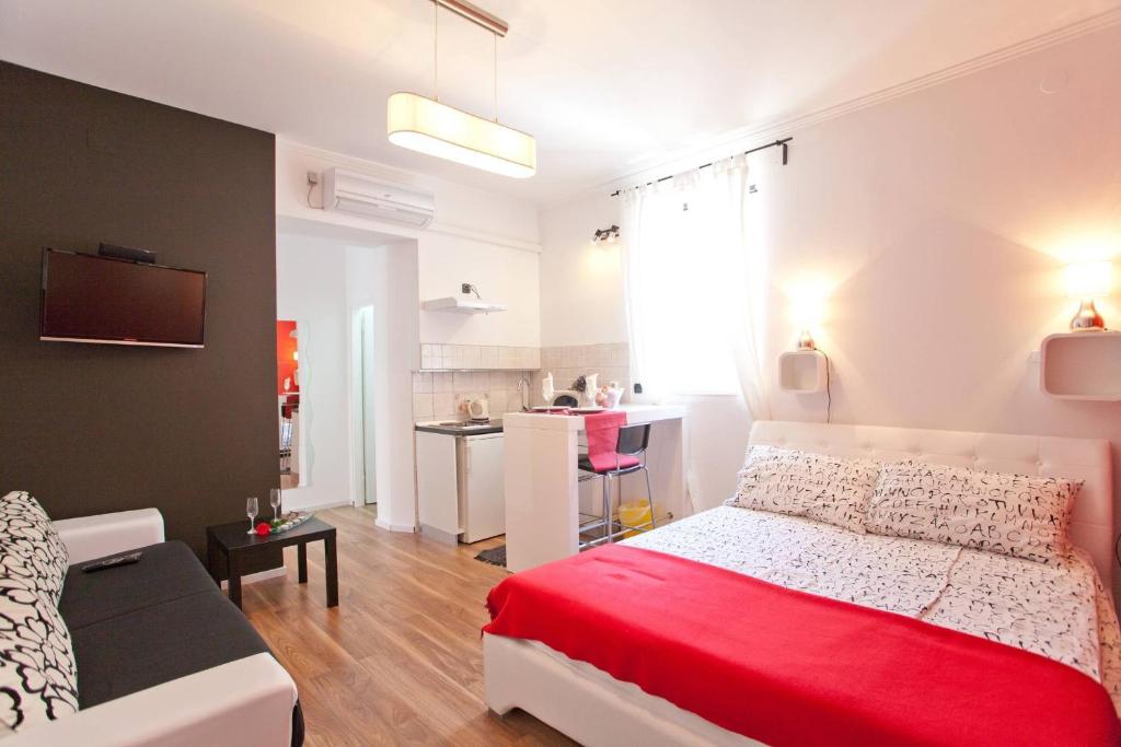 a bedroom with a red bed and a couch at Apartments Top Center in Zagreb