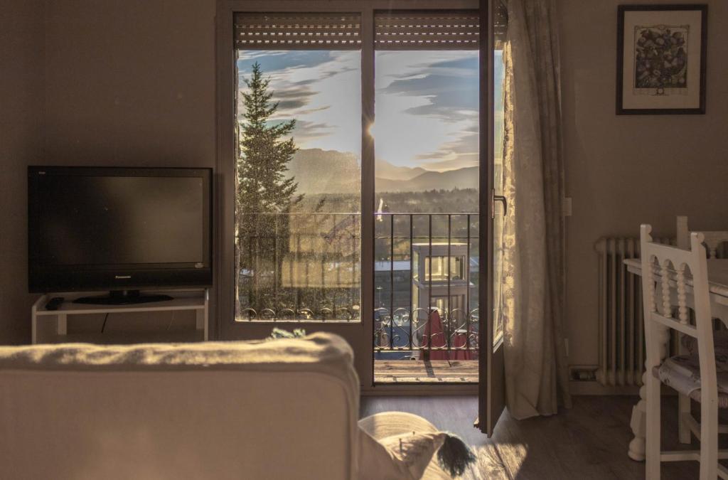 uma sala de estar com uma grande janela e uma televisão em Vistas espectaculares en el centro de Puigcerdà em Puigcerdà