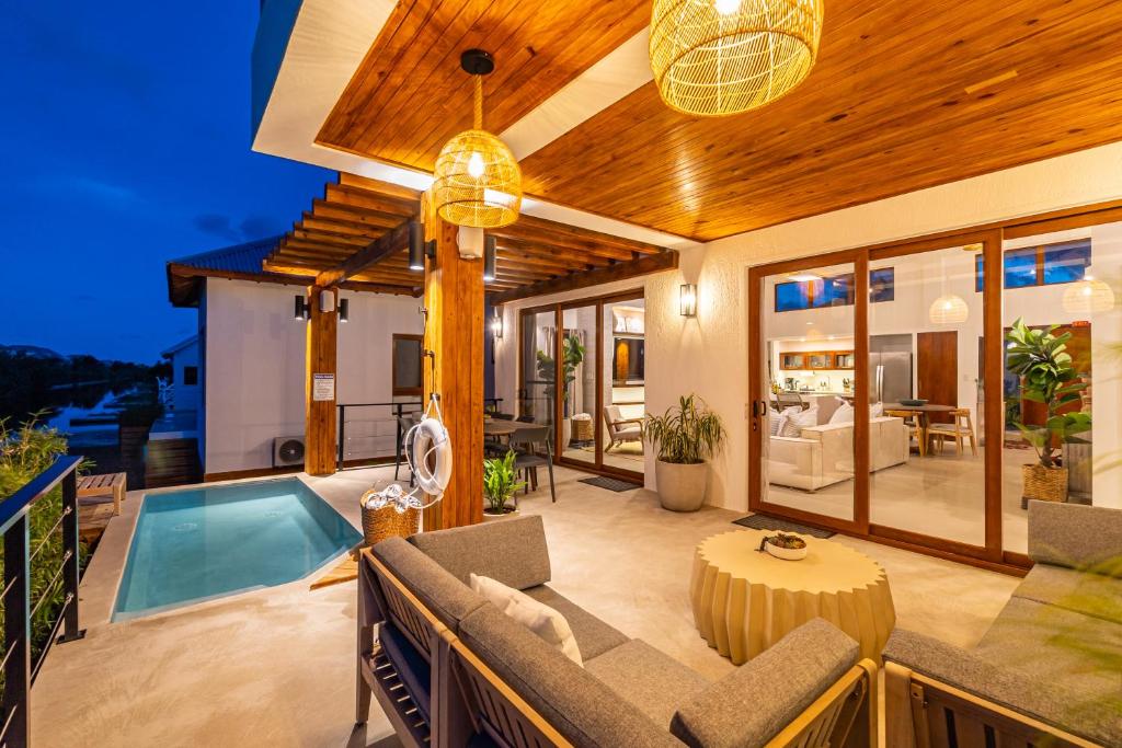 a living room with a pool and a house at Casa Brisa & The PoolClub at Mahogany Bay! in San Pedro