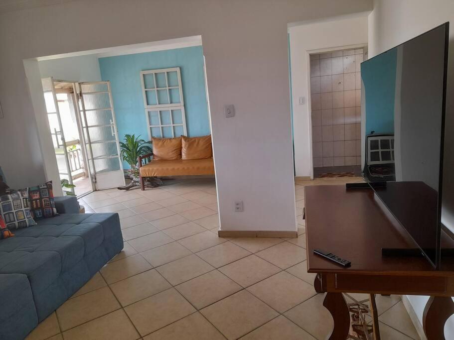 a living room with a couch and a tv at Apartamento Inconfidência Diamantina in Diamantina