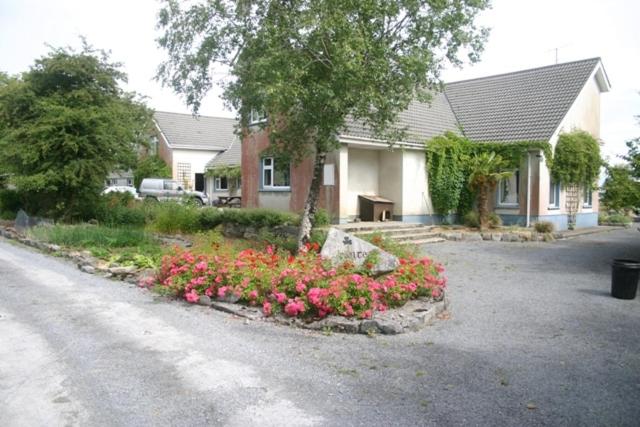 uma casa com um ramo de flores na entrada em Portarra Lodge Guesthouse em Moycullen