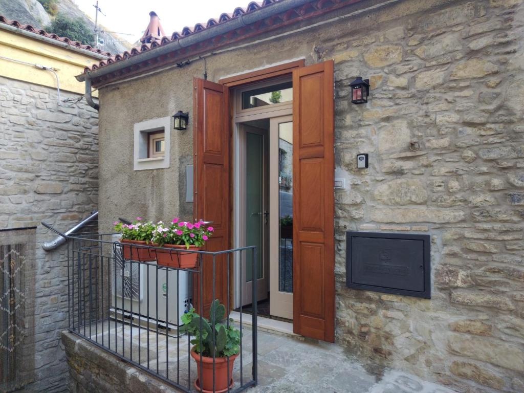 una porta con due piante in vaso su un balcone di Domus Al.Me a Castelmezzano