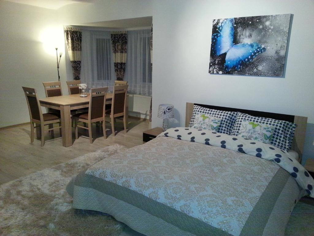 a bedroom with a bed and a dining room at Spa Park Guest Rooms in Długopole-Zdrój
