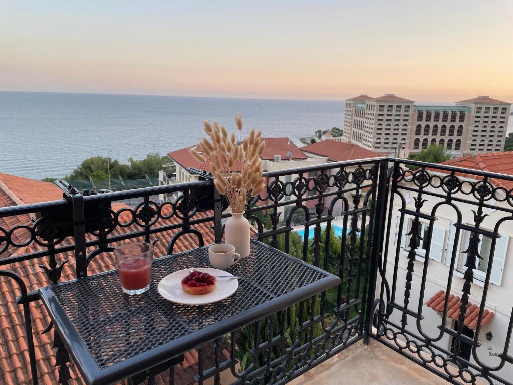 een tafel met een bord eten op een balkon bij 2 pièces BeHappy next Monaco in Roquebrune-Cap-Martin