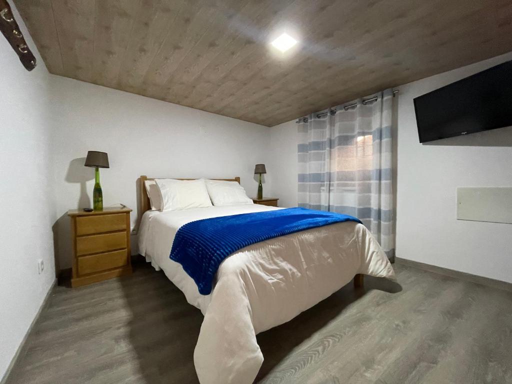 a bedroom with a bed and a television in it at Abrigo do Outeiro - Serra Da Estrela in Cabeça