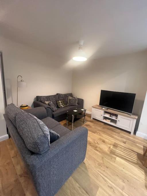 a living room with a couch and a flat screen tv at Solihull house weekly/ monthly in Sheldon