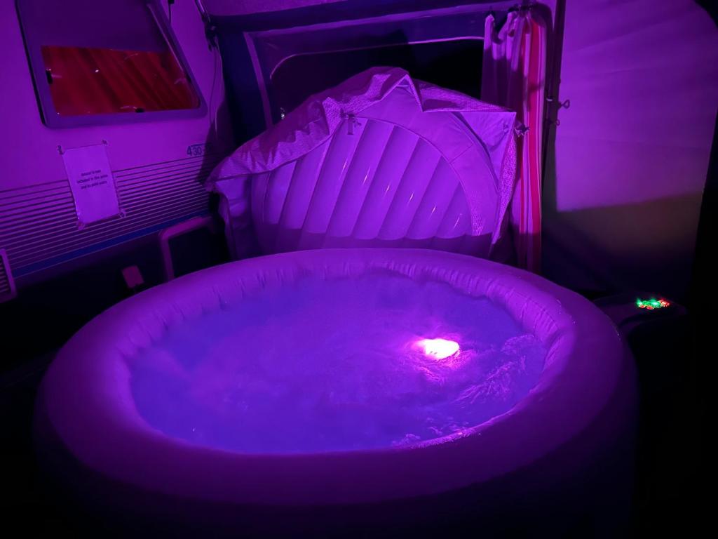 a purple room with a tub with a candle in it at Jacuzi Cottage in the olive grove in Pula