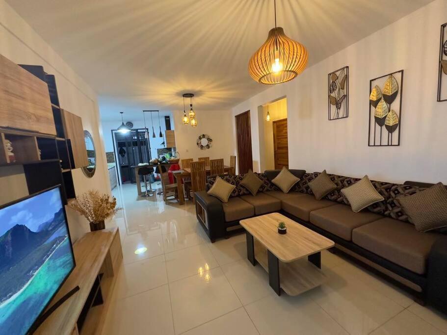 sala de estar con sofá, mesa y TV en SeaSand-Entire Luxury 3 BD condo - Close to beach, en Flic en Flac
