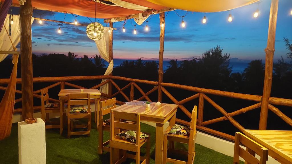 un restaurante con mesas y vistas a la puesta de sol en Casa Vainilla Holbox Island, en Isla Holbox