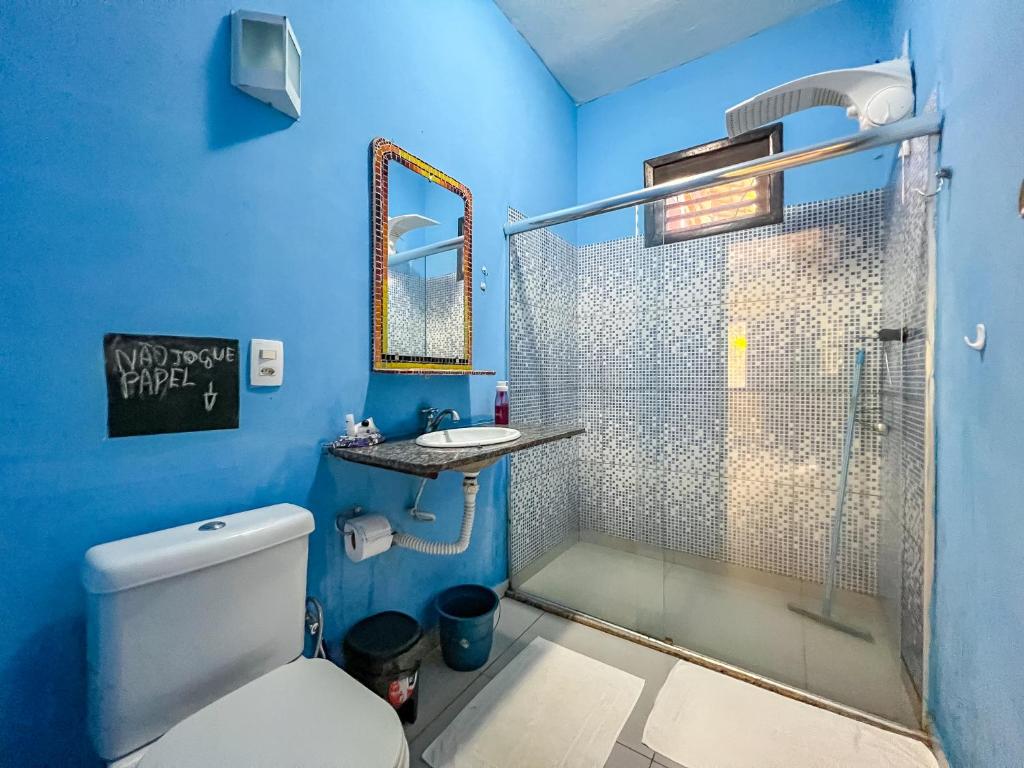 La salle de bains bleue est pourvue de toilettes et d'une douche. dans l'établissement Barra Quintal - Studio 2, à Barra Grande