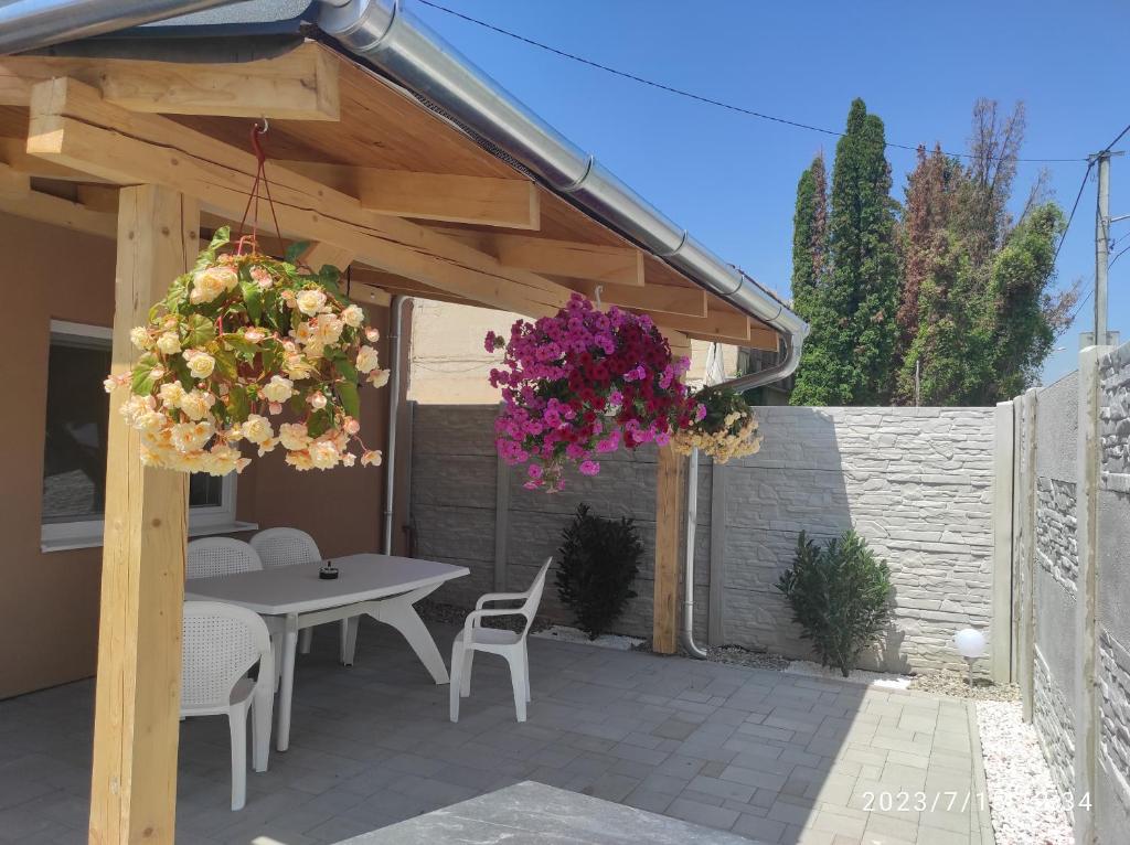 um pátio com uma mesa, cadeiras e flores em Andrea ubytovanie em Štúrovo