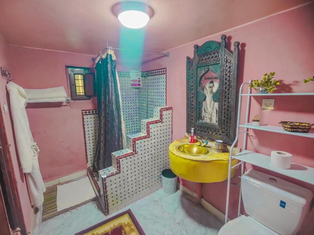 un bagno rosa con lavandino giallo e doccia di Ryad Zahrat Fes a Fes