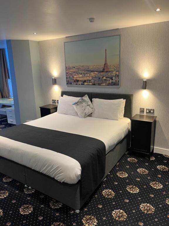 1 dormitorio con 1 cama grande y una foto de la torre Eiffel en Shores Holiday Apartments, en Blackpool