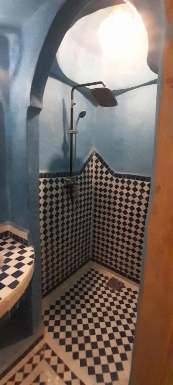 a bathroom with a black and white checkered floor at Camels House in Merzouga