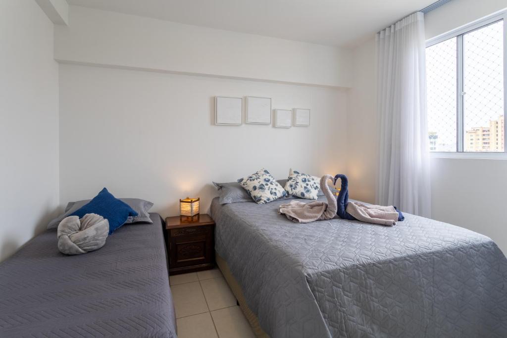 a bedroom with two beds with towels on them at Apartamento com VISTA MAR, Ar-condicionado, Wi-Fi Condomínio com PISCINA, quadra de esportes Playground infantil a 15 minutos do Beto Carreiro in Piçarras