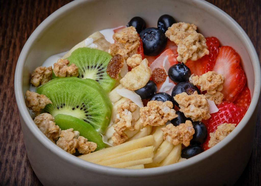 a bowl of fruit and cereal with kiwi kiwis kiwi at Boutique Hotel OLOM - Only Adults recommended in Cádiz