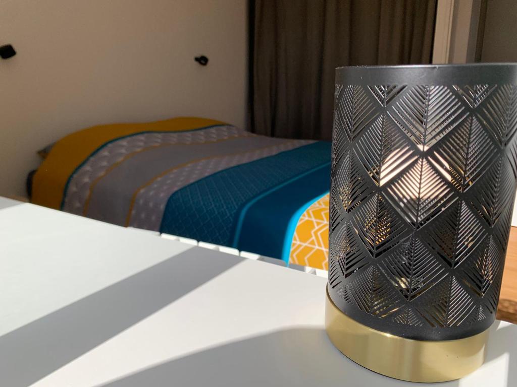 eine schwarze und goldene Lampe auf einem Tisch in einem Schlafzimmer in der Unterkunft Le Chazottier in Brindas
