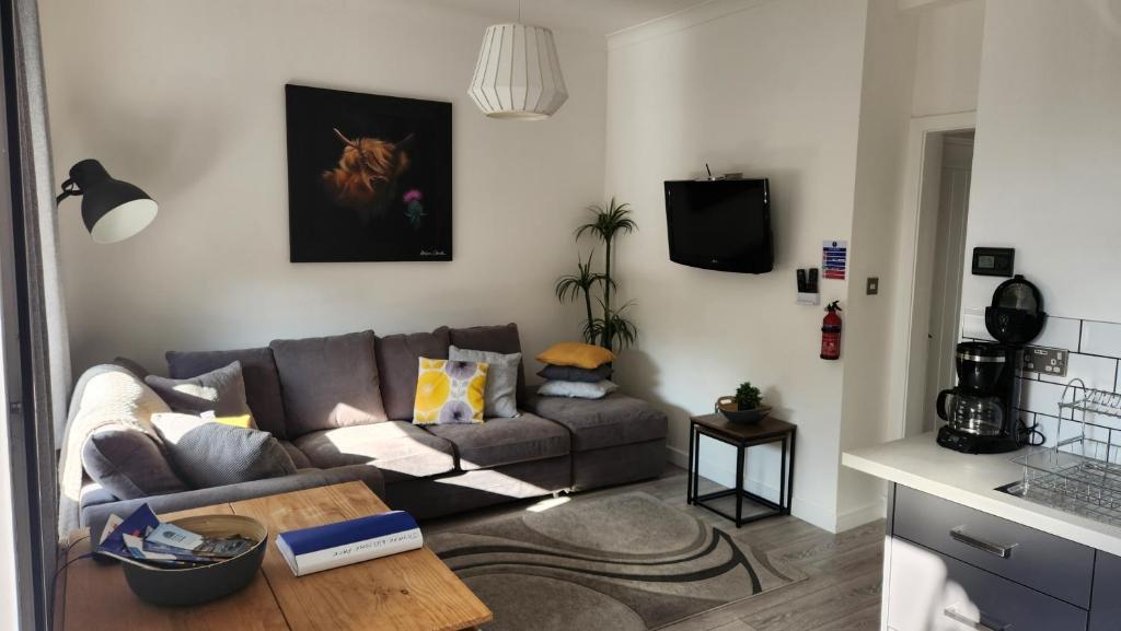 uma sala de estar com um sofá e uma mesa em Jaymar em Fife