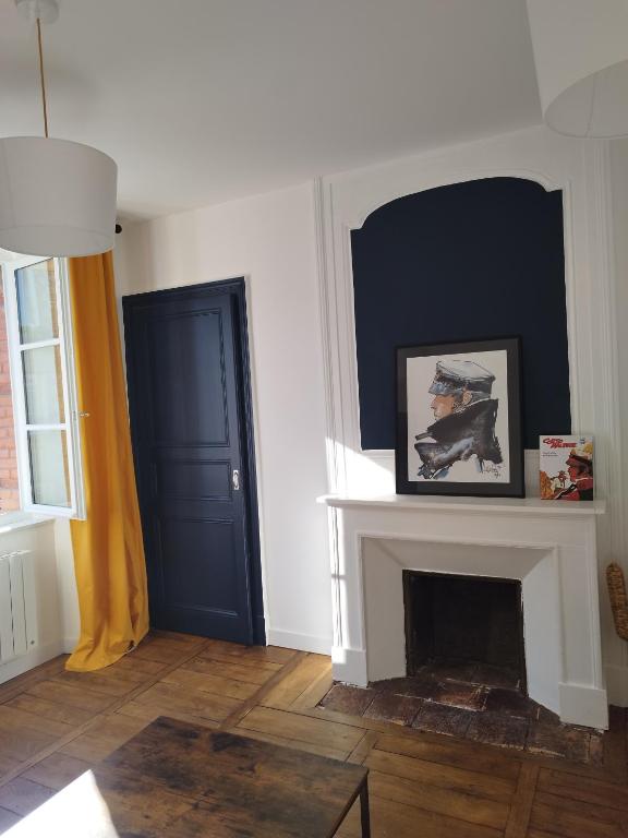 a living room with a fireplace and a blue door at ROMANESCO in Rennes