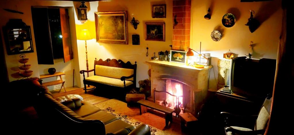 a living room with a fireplace and a couch at Casa da Avó 