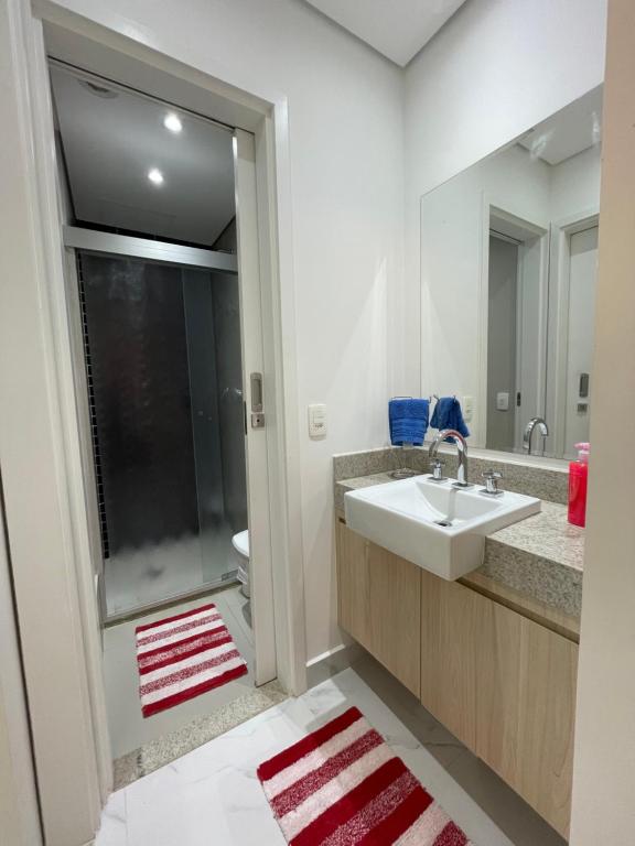 een badkamer met een wastafel en een douche bij Residencial Estanconfort Santos in Santos