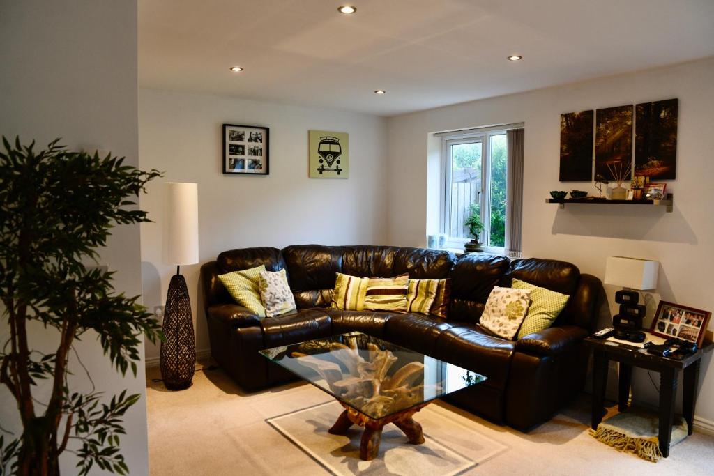 sala de estar con sofá de cuero y mesa de cristal en Holly Crescent, Sacriston DH7, en Sacriston