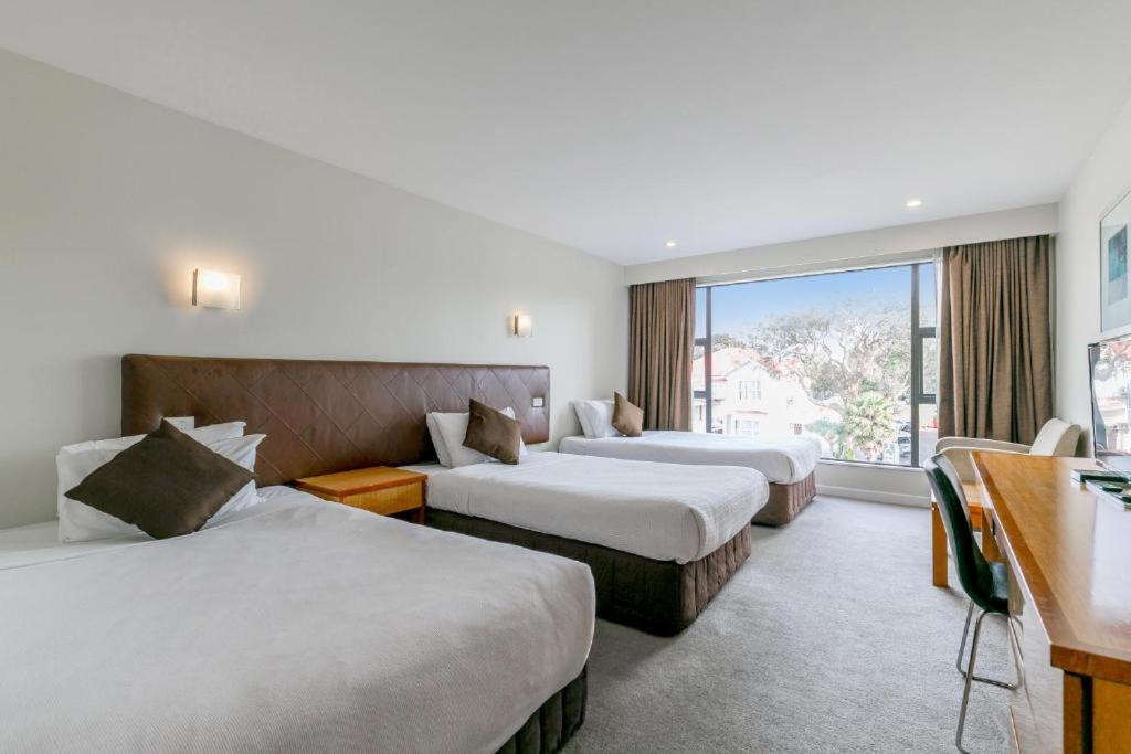 um quarto de hotel com duas camas e uma janela em Boulevard Hotel em Auckland