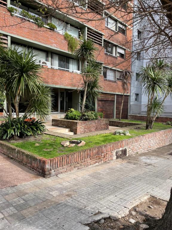 een bakstenen gebouw met palmbomen ervoor bij Apartamento recién renovado en Punta Carretas in Montevideo