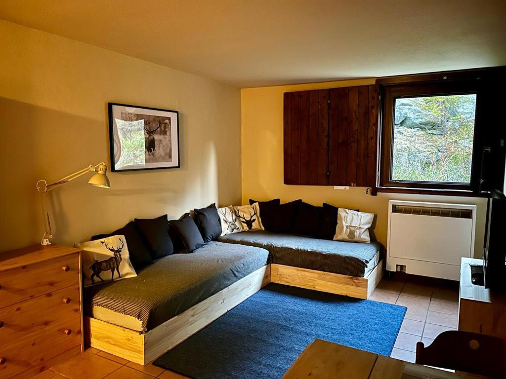 ein Wohnzimmer mit einem Sofa und einem Fenster in der Unterkunft Cervinia Studio in Breuil-Cervinia