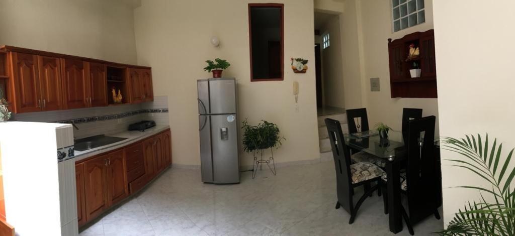 a kitchen with a stainless steel refrigerator and a table at Guadalupe ApartaHotel Calle 9 5-66 Apartamento 102 in Jardin