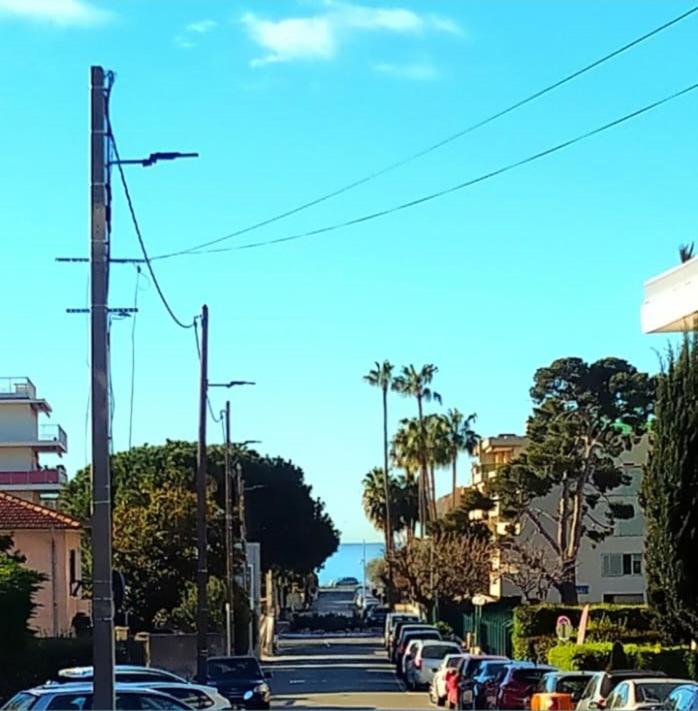 une rue avec des voitures garées sur le bord de la route dans l'établissement Cabane pas loin de la plage, à Cagnes-sur-Mer
