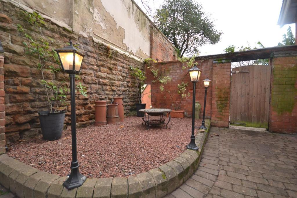 two lights in a courtyard with a table and a building at The Castle Apartment, Lots of Character Cosy and Comfortable, Private Garden and FREE Parking in Nottingham