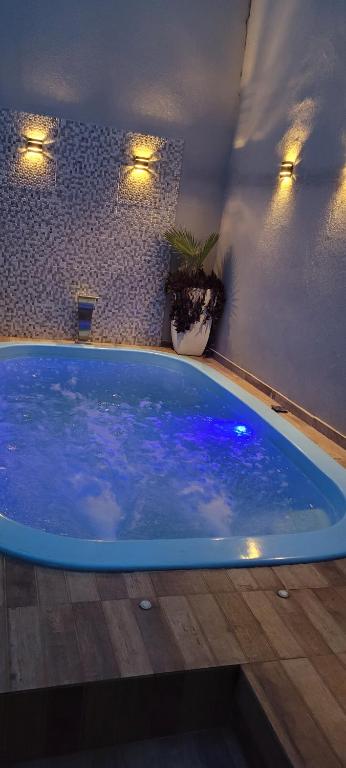 una gran piscina con luces azules en una habitación en Recanto Dimarco com Piscina!, en Olímpia