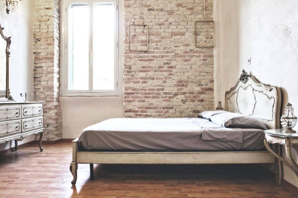Casa Particular Vintage في روما: غرفة نوم بسرير وجدار من الطوب