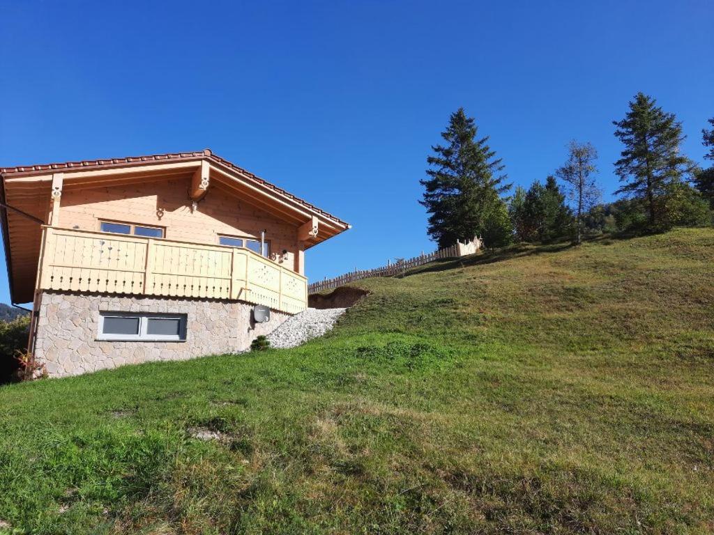 a house on the side of a grassy hill at Herzbluad Chalet in Wallgau