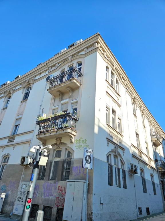 a white building with a balcony on the side of it at Booking Apartment Rajiceva in Belgrade