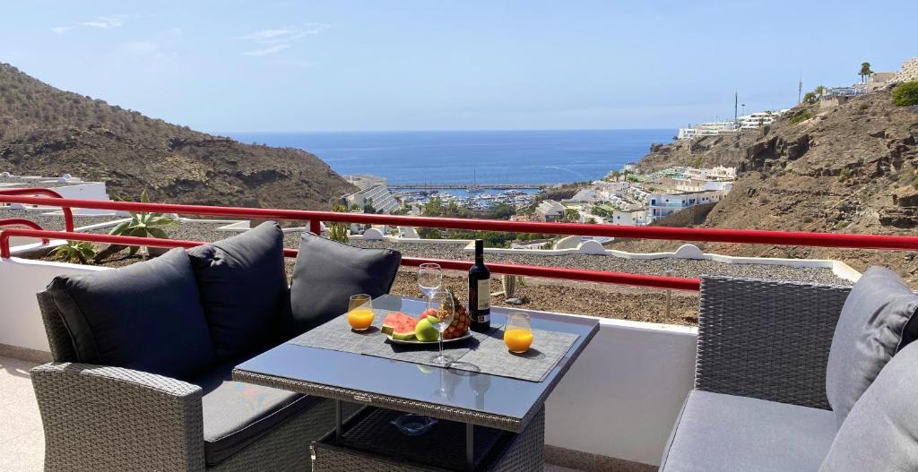 a table with drinks and a bowl of fruit on a balcony at Inagua Sol apartment in Puerto Rico de Gran Canaria