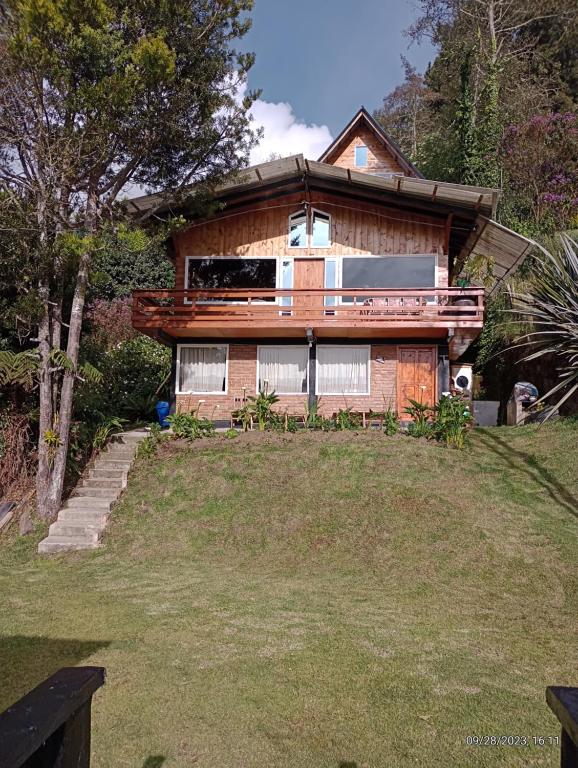 uma casa no topo de uma colina com um quintal em cabañas Arcoíris del lago Nº 2 em Pasto