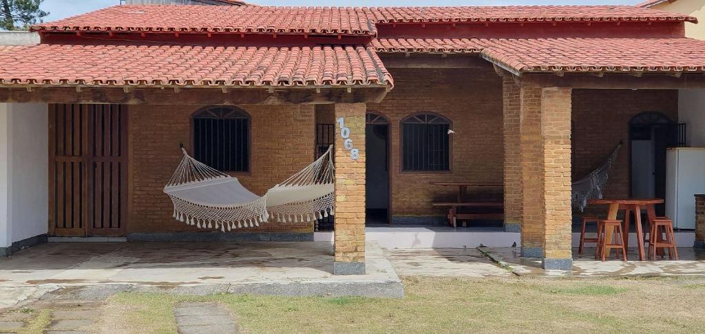 ein Haus mit zwei vom Dach hängenden Hängematten in der Unterkunft Casa Temporada Guriri Beira-Mar in Guriri