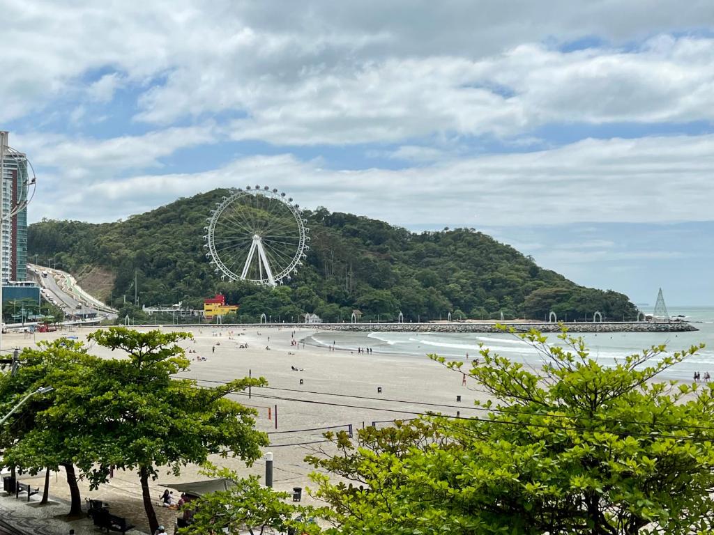 a beach with a ferris wheel in the background at Apartamento 3 quartos e boas energias in Balneário Camboriú