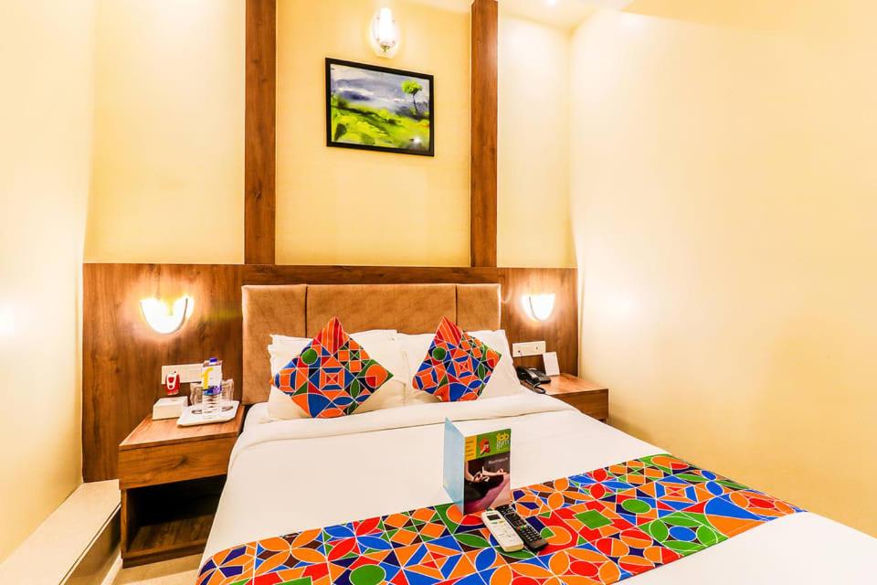 達卡的住宿－Hotel Grand Rahmania, Central Motijheel-Dhaka，一间卧室配有一张带五颜六色棉被的床