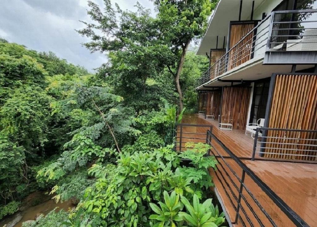 a balcony of a house with trees and bushes at Maesa Greenery Hill SHA in Mae Rim