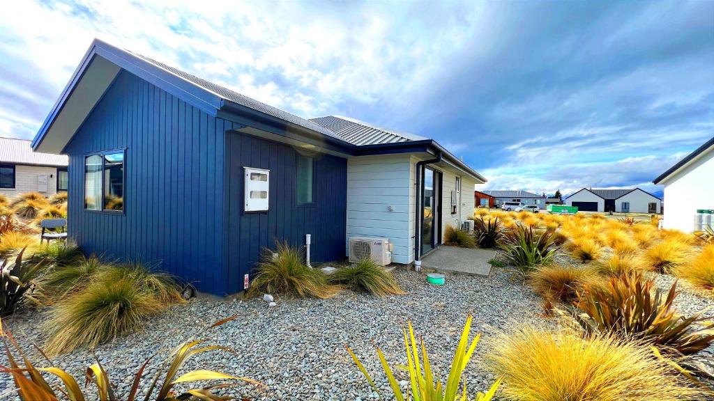 a blue house with plants in front of it at Number 12 Apartment in Lake Tekapo