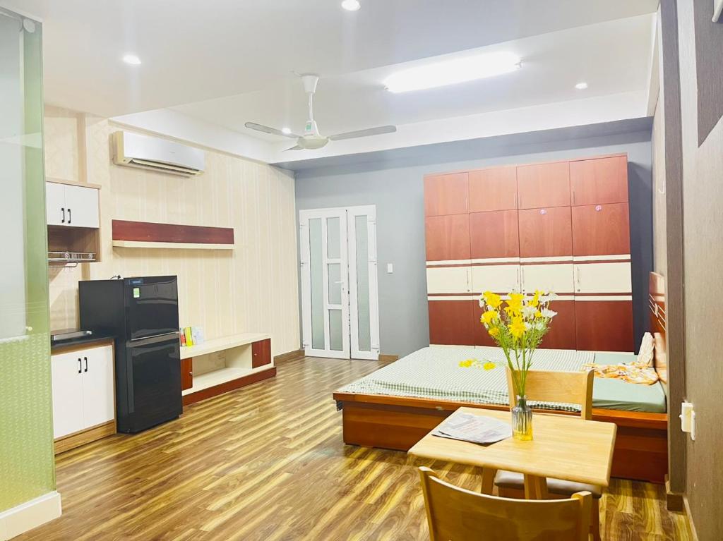 um quarto com uma cozinha e uma mesa com flores em Lyn'house em Ho Chi Minh