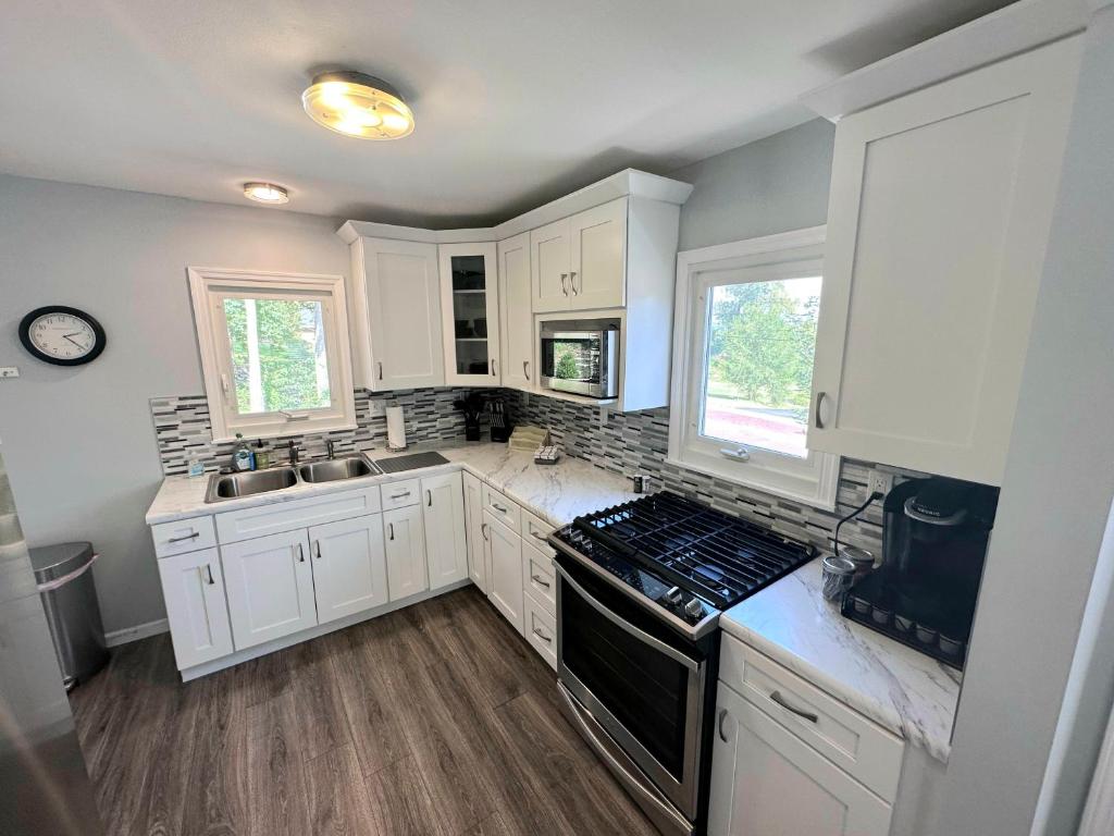 a kitchen with white cabinets and a stove top oven at Charming Duplex on Main in St. Charles