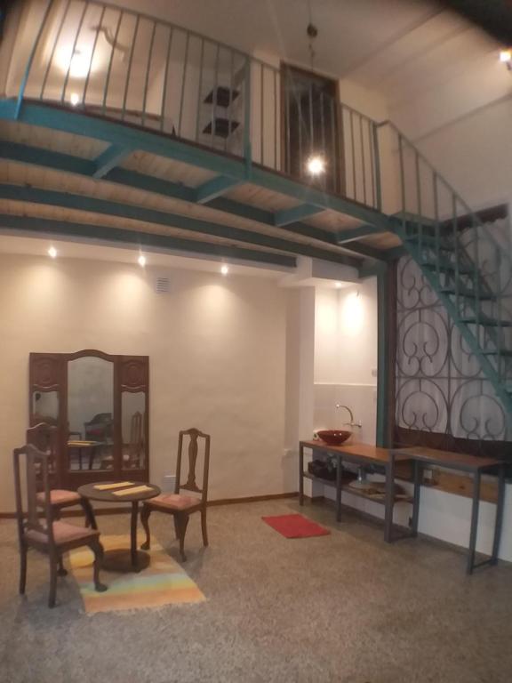 Habitación con escalera, mesa y espejo. en Style Loft en Buenos Aires